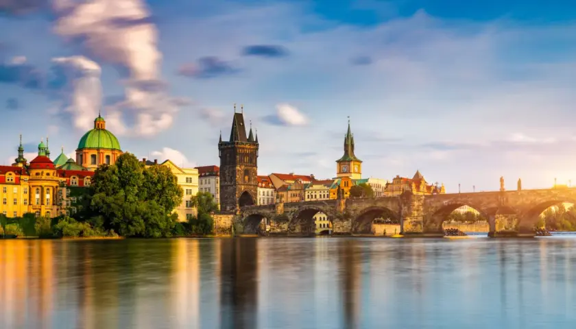 El Puente de Carlos y la arquitectura histórica de Praga reflejados en el río Moldava. Un plan perfecto para disfrutar de Praga en 3 días.