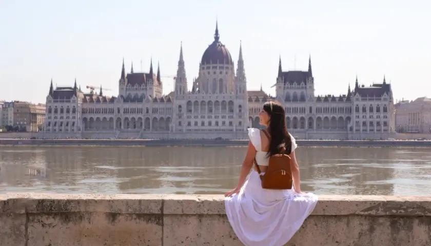Mujer con mochila admira el Parlamento de Budapest. ¿Cuántos días para ver Budapest? ¡Un viaje inolvidable!