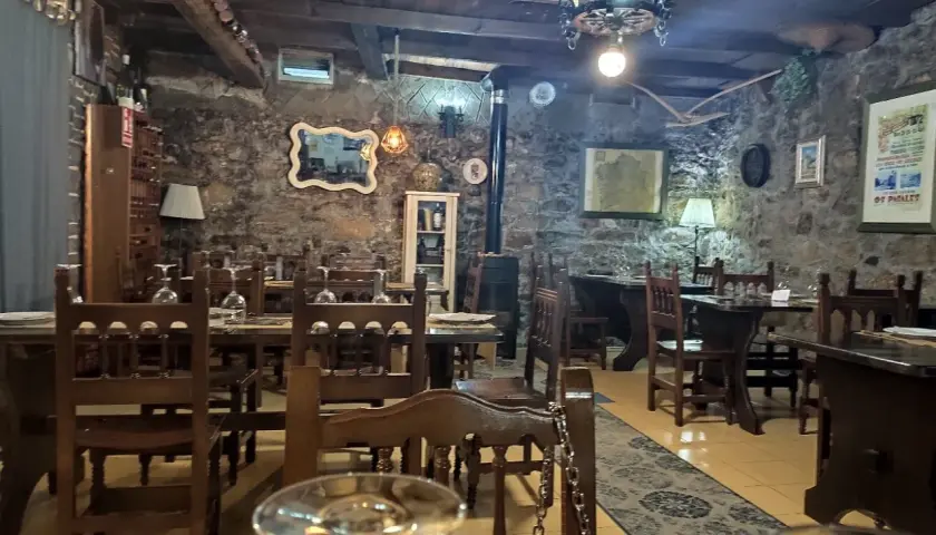 Ambiente rústico con mesas de madera y piedra, ideal para saber donde comer en Noia.