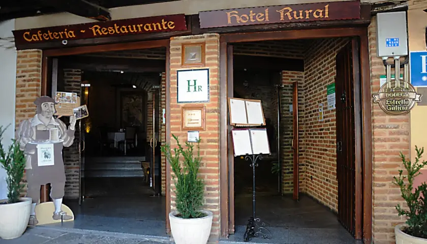 Entrada a Cafetería-Restaurante y Hotel Rural. Un cartel de un camarero invita a descubrir dónde comer en Guadalupe.
