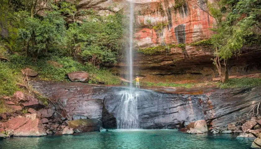 Cascada en Paraguay con un hombre disfrutando. ¡Un lugar increíble que ver en Paraguay!