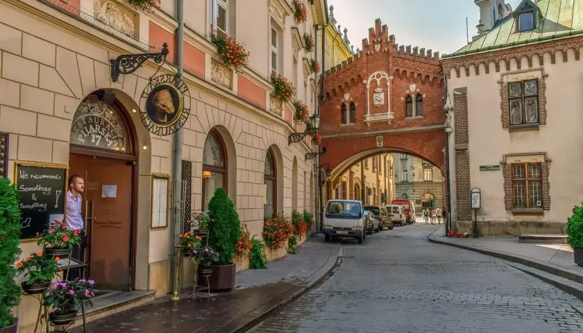 Un hombre mira desde una cafetería en Cracovia, una ciudad que ver en 3 días. Calles empedradas y arquitectura histórica.