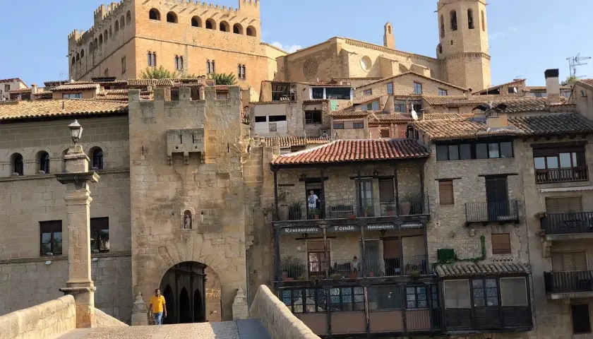 Un hombre cruza el puente hacia el castillo de Valderrobres, un lugar que ver para disfrutar de su arquitectura medieval y sus calles empedradas.