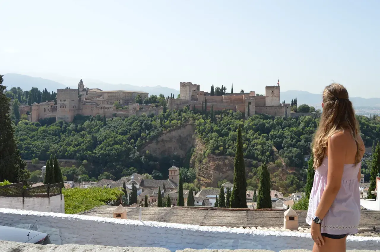 Una mujer contempla la Alhambra, un lugar imprescindible que ver en Granada en 3 días.