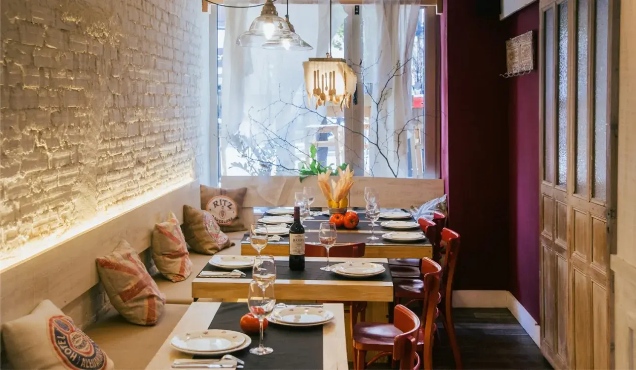 Mesas puestas en un restaurante acogedor, ideal para saber donde comer en Santander. Ambiente rústico con detalles de madera y ladrillo.