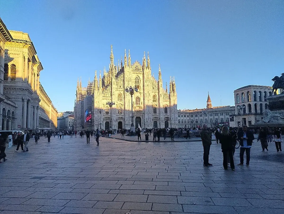 Plaza del Duomo de Milán con el sol de la tarde. Gente paseando, ideal para un free tour Milán.