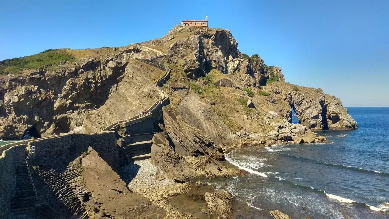 Escaleras de piedra ascienden a una ermita en la cima de un acantilado rocoso. Un lugar imprescindible que ver en Bermeo.