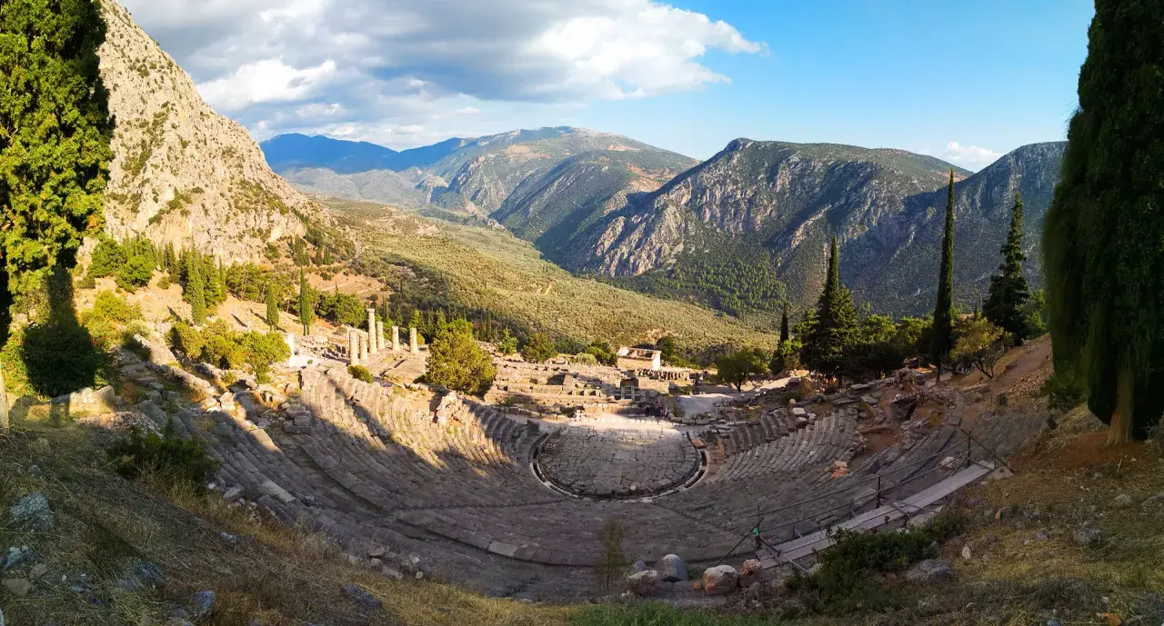 Teatro antiguo en Delfos, Grecia. Un lugar imprescindible que ver en Grecia en una semana, con vistas a montañas y ruinas.