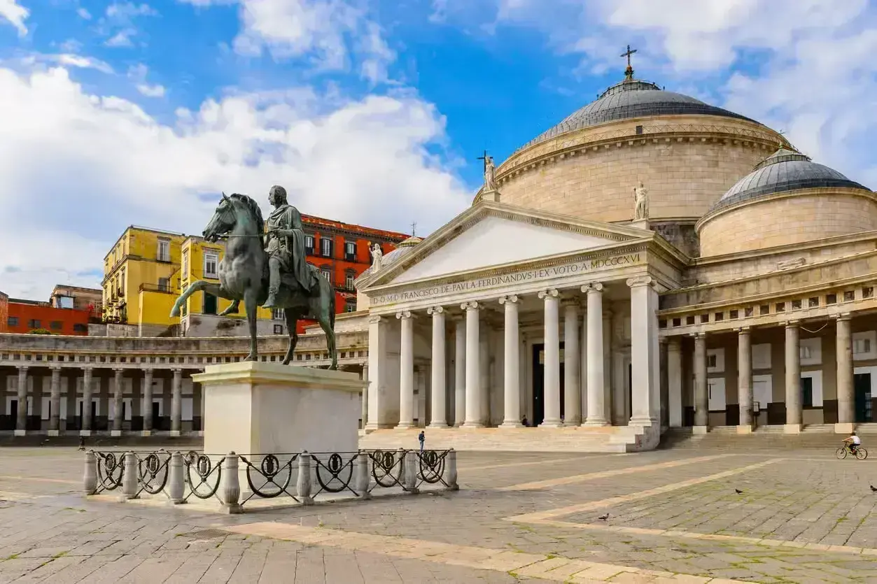 Plaza con estatua ecuestre y el Palacio Real de Nápoles, ideal para un free tour Nápoles.