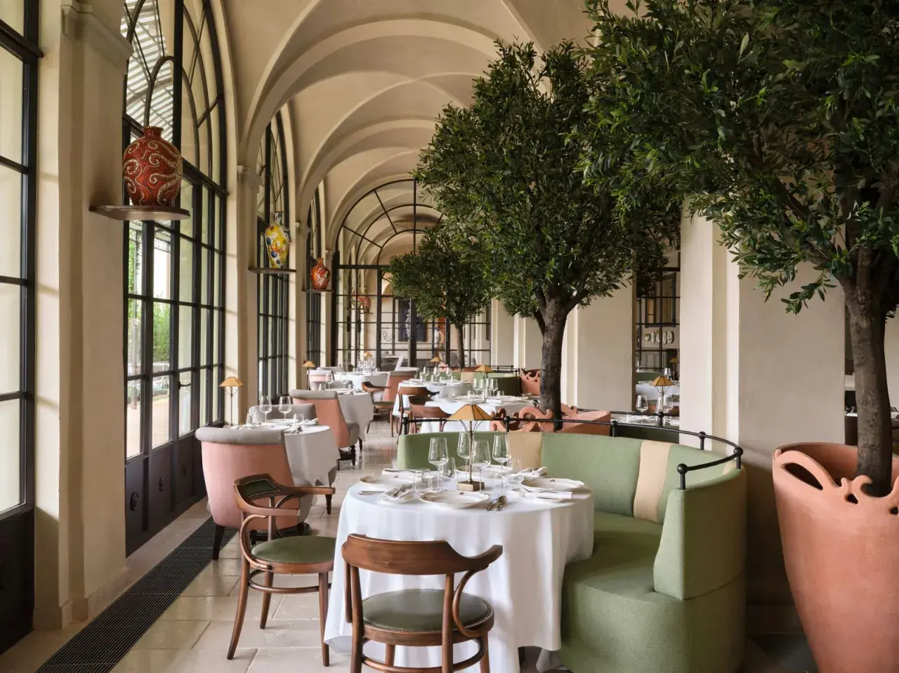 Elegante comedor con mesas vestidas y árboles de olivo, ideal para saber donde comer en Florencia.