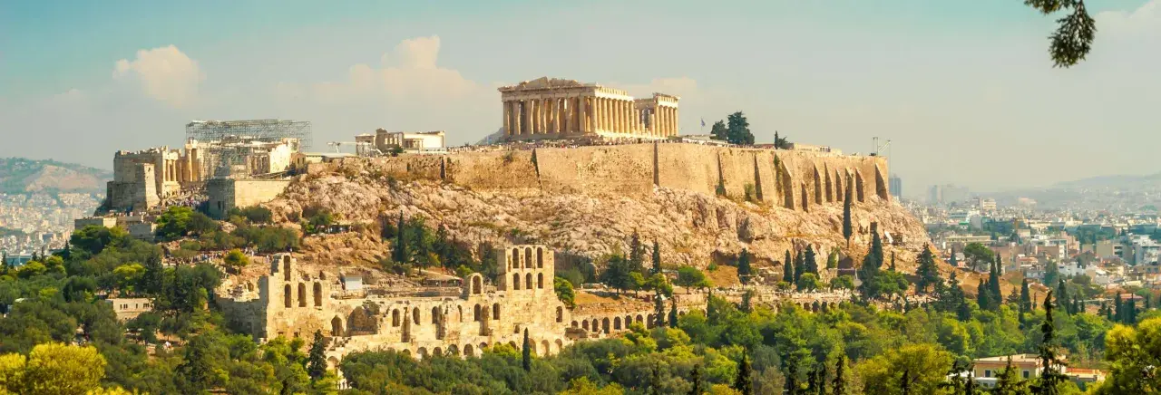 La Acrópolis de Atenas, un destino icónico para excursiones desde Atenas, se alza majestuosa sobre la ciudad.