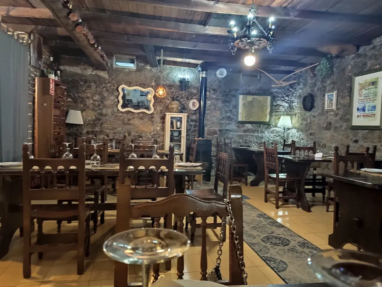 Ambiente rústico con mesas de madera y piedra, ideal para saber donde comer en Noia.