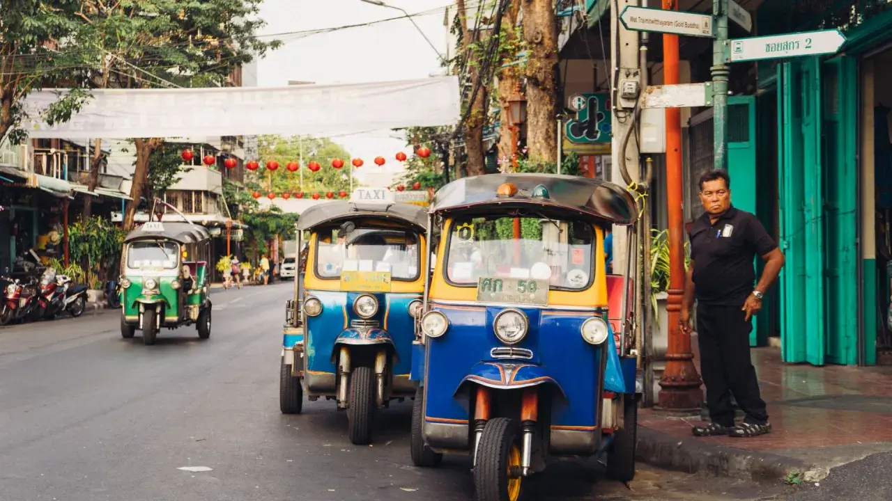 Tuk-tuks coloridos en una calle de Bangkok, perfectos para explorar la ciudad. ¡La mejor época para viajar a Tailandia es ahora!