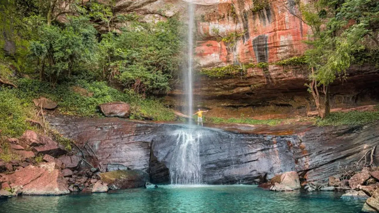 Cascada en Paraguay con un hombre disfrutando. ¡Un lugar increíble que ver en Paraguay!