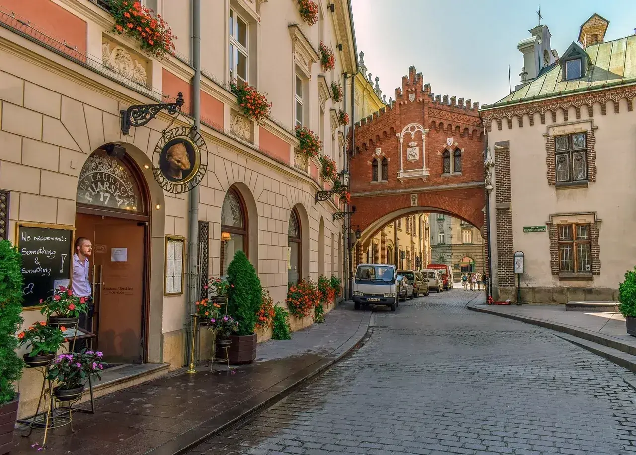 Un hombre mira desde una cafetería en Cracovia, una ciudad que ver en 3 días. Calles empedradas y arquitectura histórica.