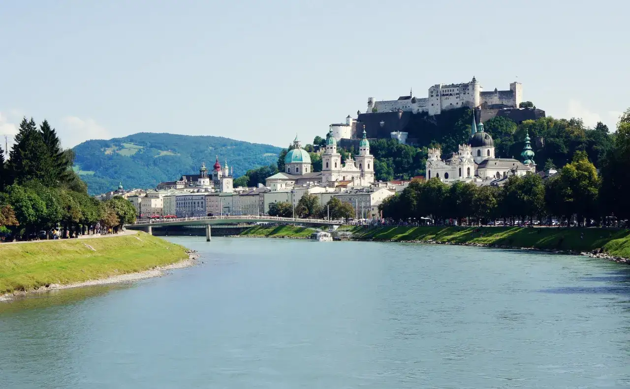 Vista del r&iacute;o Salzach con la fortaleza Hohensalzburg y la ciudad al fondo. Un d&iacute;a perfecto para descubrir qu&eacute; ver en Salzburgo.