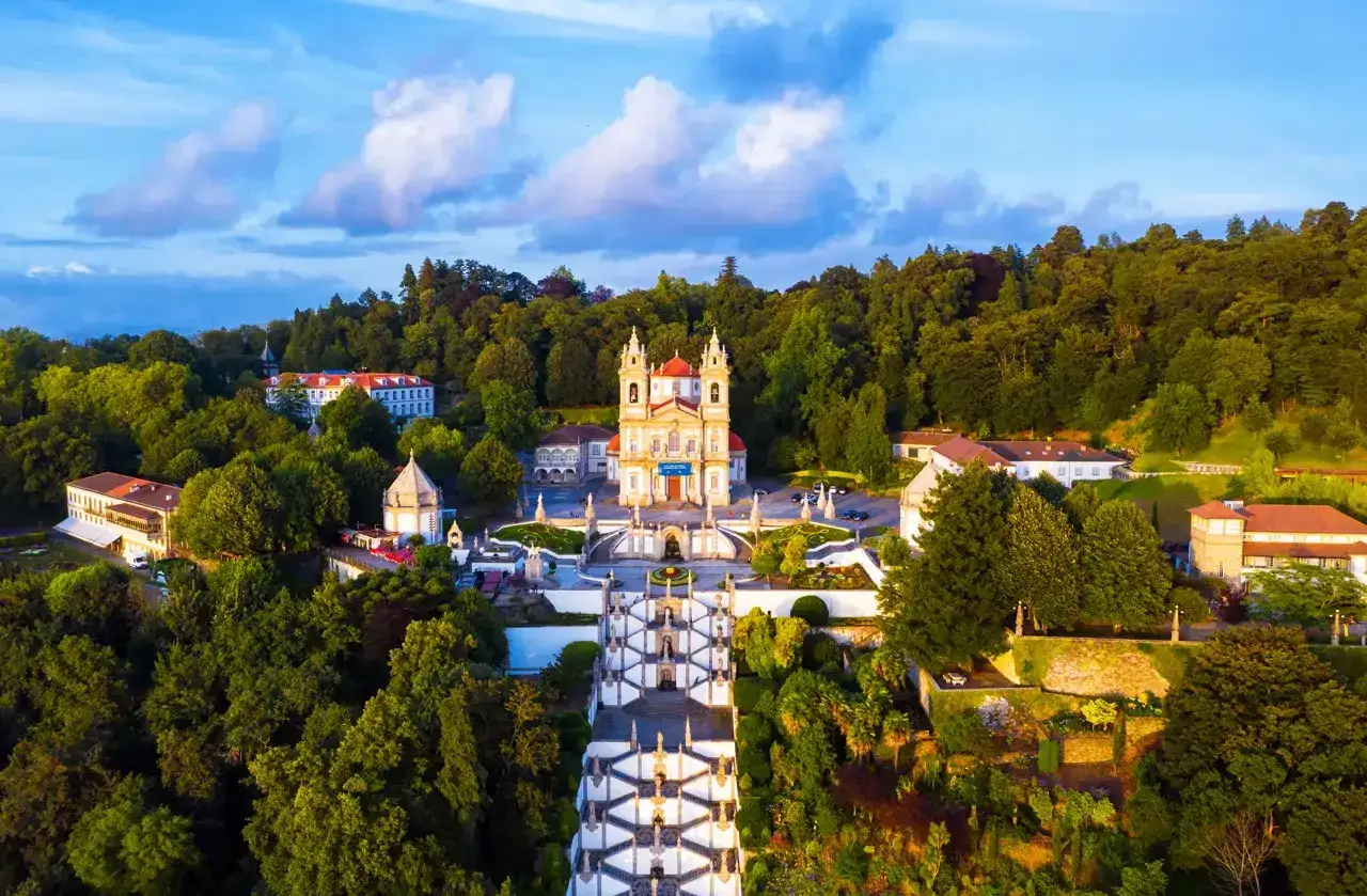 Impresionante vista aérea del Santuario del Bom Jesus do Monte, un lugar clave que ver en Braga, con su icónica escalinata y rodeado de exuberante vegetación.