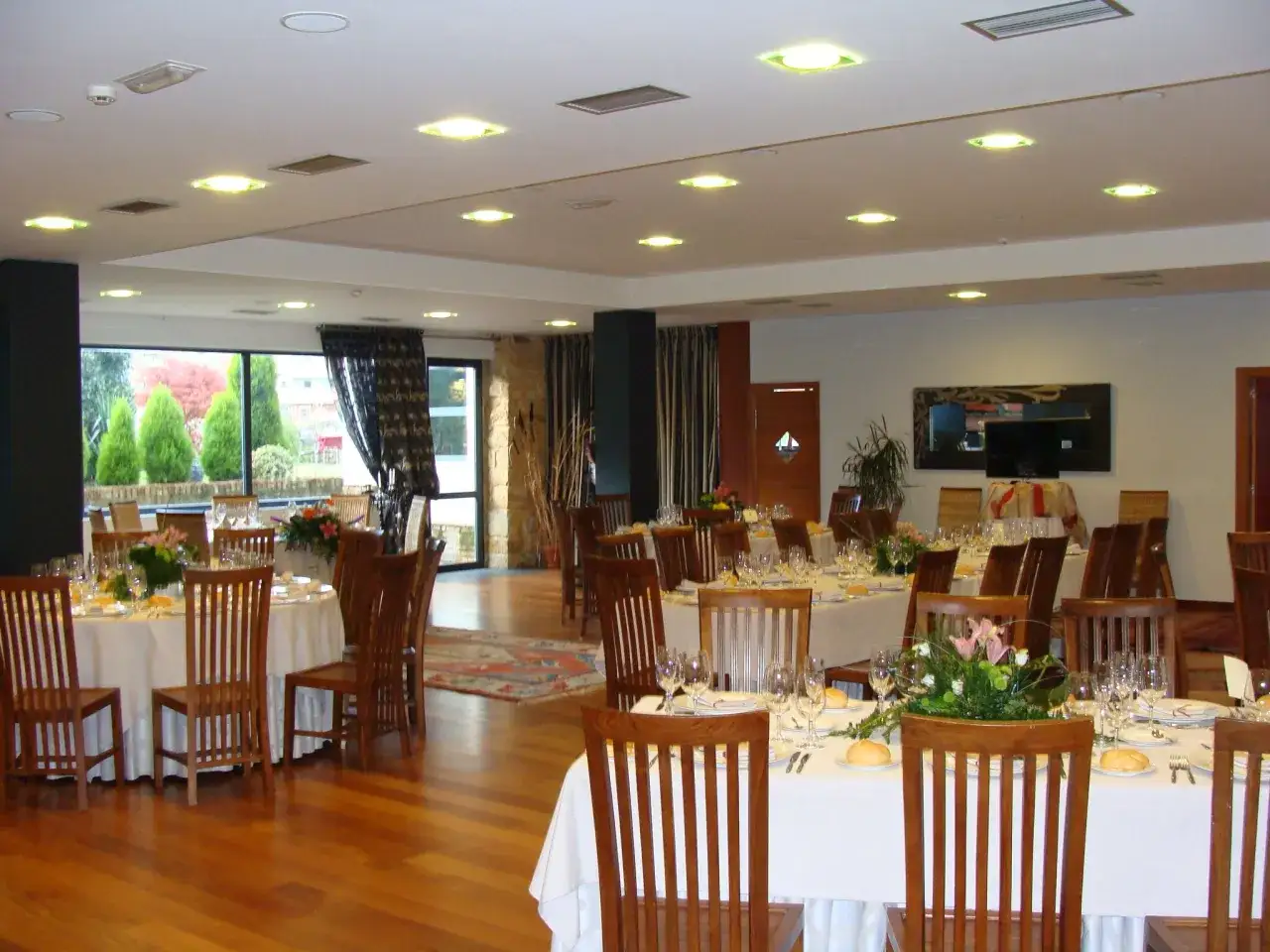 Sal&oacute;n de eventos con mesas puestas, ideal para saber donde comer en Lierganes.