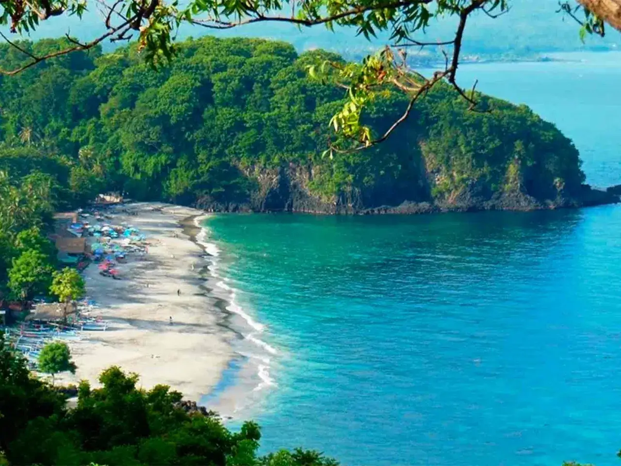 Playa tropical con aguas turquesas y vegetación exuberante. Parece la mejor época para viajar a Bali, con un día soleado y tranquilo.