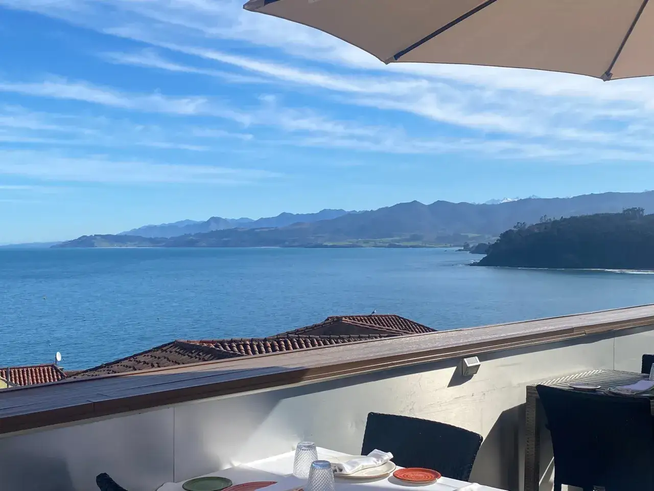 Mesa puesta con vistas al mar y montañas, ideal para saber donde comer en Lastres.
