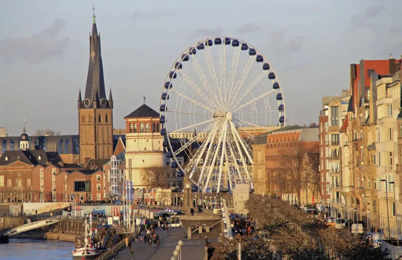 Rueda de la fortuna y arquitectura hist&oacute;rica en D&uuml;sseldorf. Un paseo fluvial con gente y barcos, ideal para saber qu&eacute; ver en D&uuml;sseldorf.